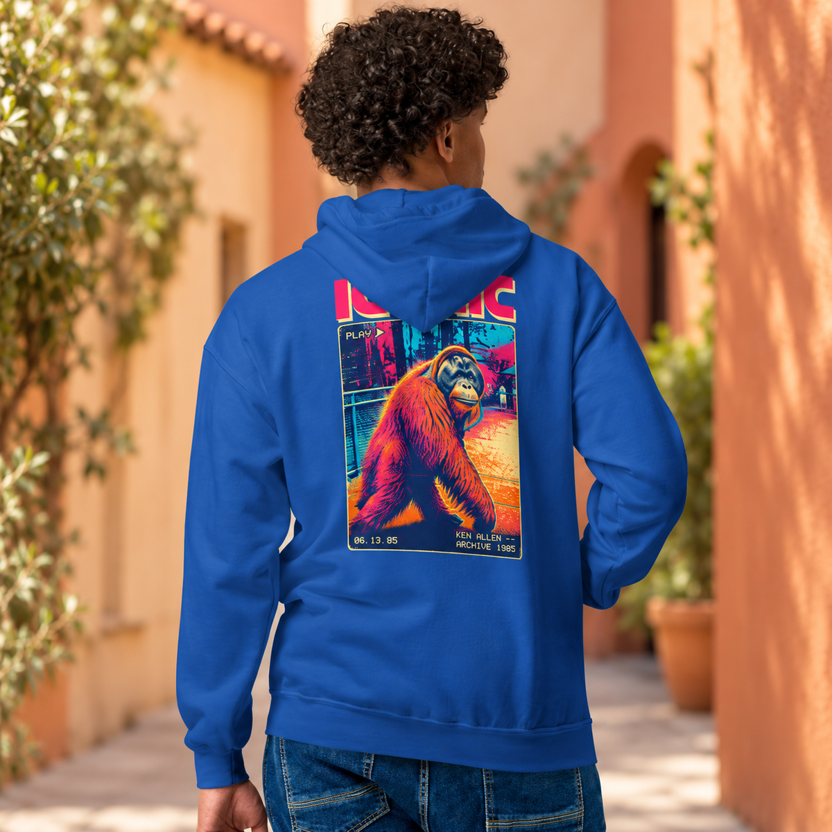 Royal blue Ken Allen Iconic zip hoodie with colorful orangutan back artwork in a terracotta courtyard