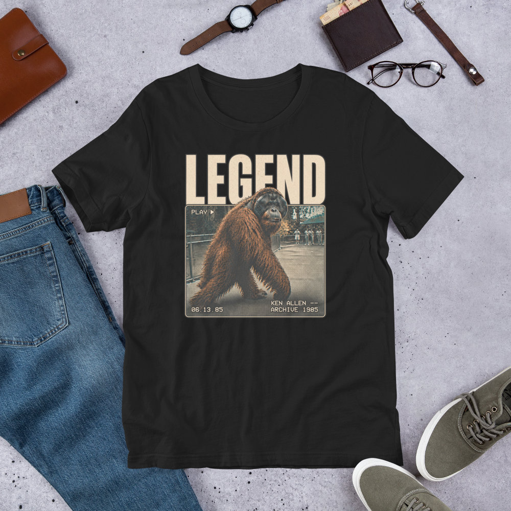 Vintage Black Ken Allen Legend graphic tee styled with jeans, olive sneakers and brown accessories in an outfit flat lay