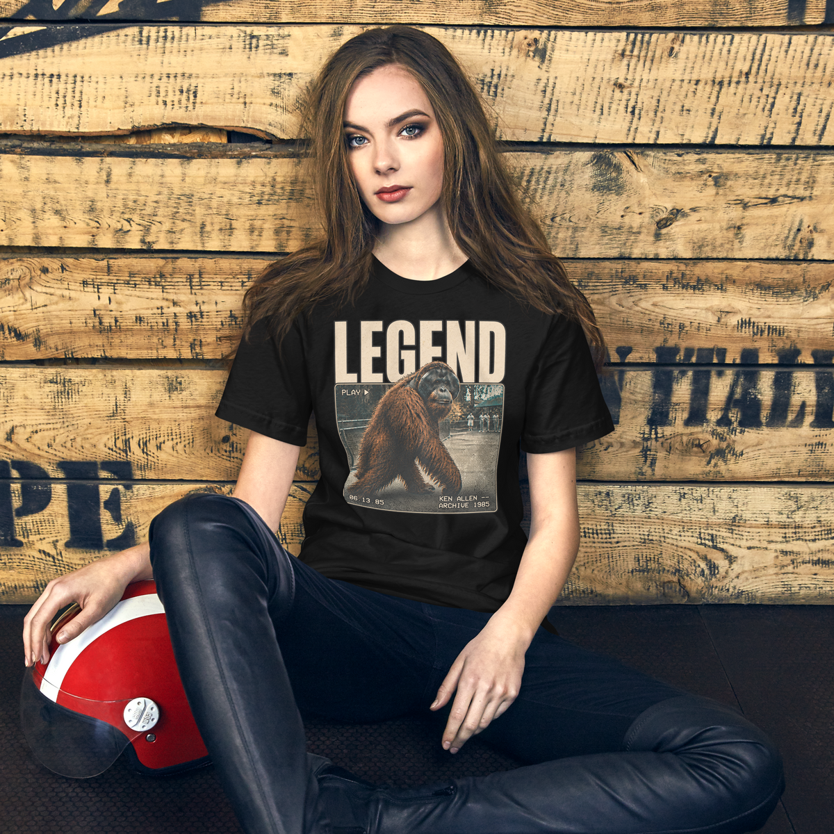 Vintage Black Ken Allen Legend tee with VHS archive artwork in a seated view against a warm wood wall